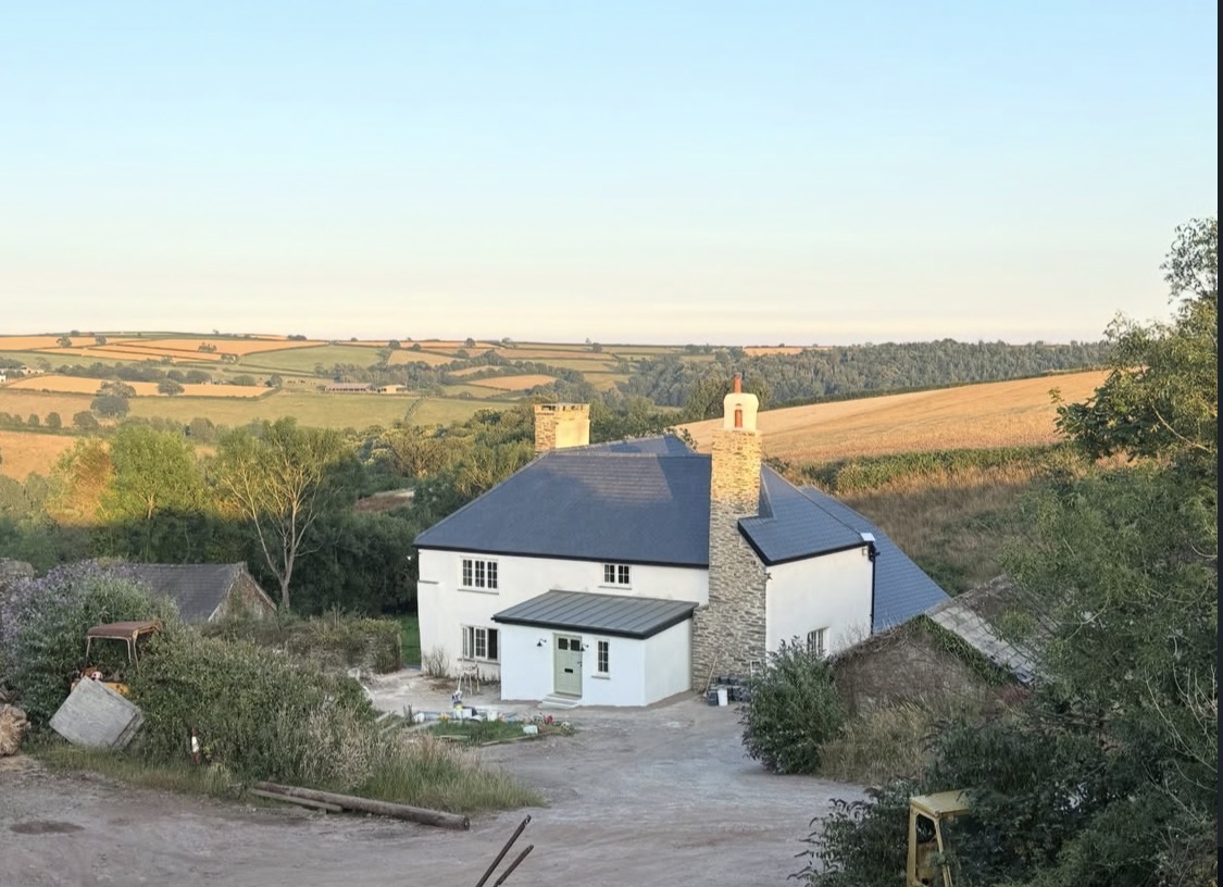 Rendered farmhouse with new slate roof and stone chimney set in the South Hams countryside