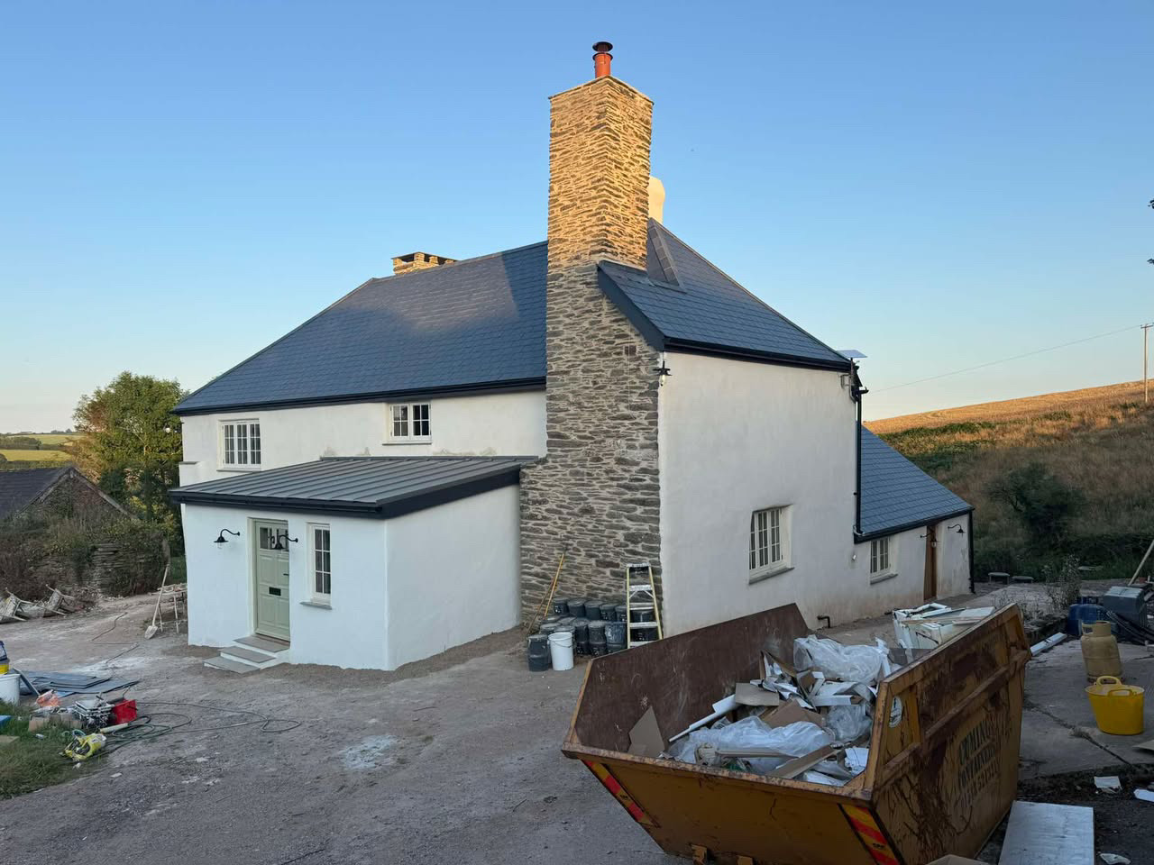 Renovated rendered farmhouse with rebuilt stone chimney and new slate roof in the South Hams countryside