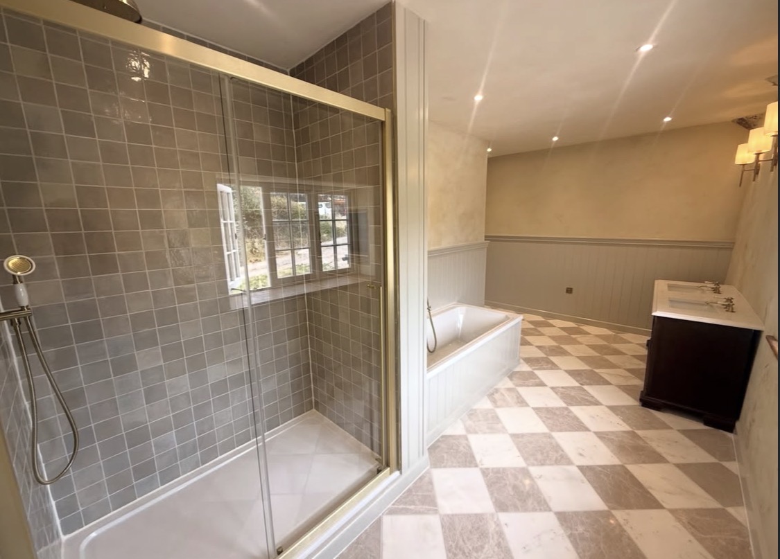 Finished bathroom with walk-in shower, panelled bath and chequerboard floor